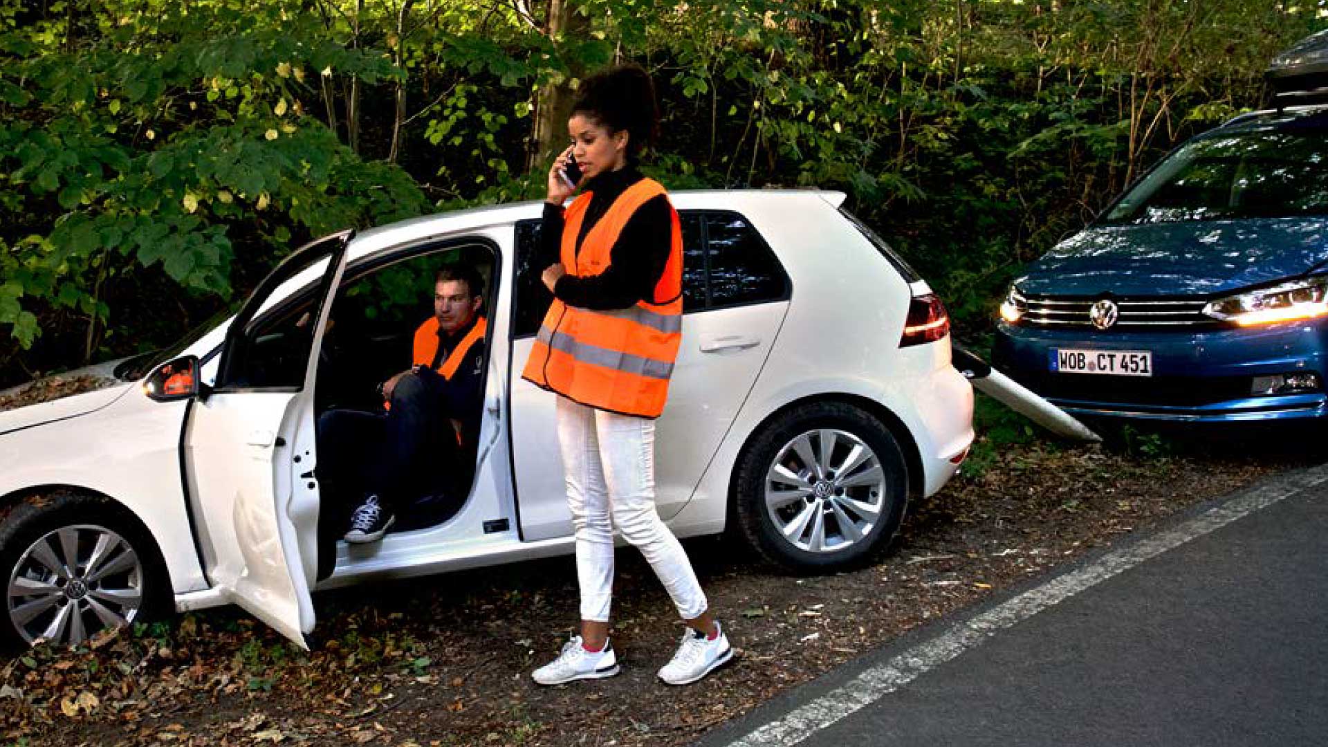 Symbolbild einer Unfallstelle, zwei Fahrzeuge, eine Frau am Telefon, keine Personenschäden