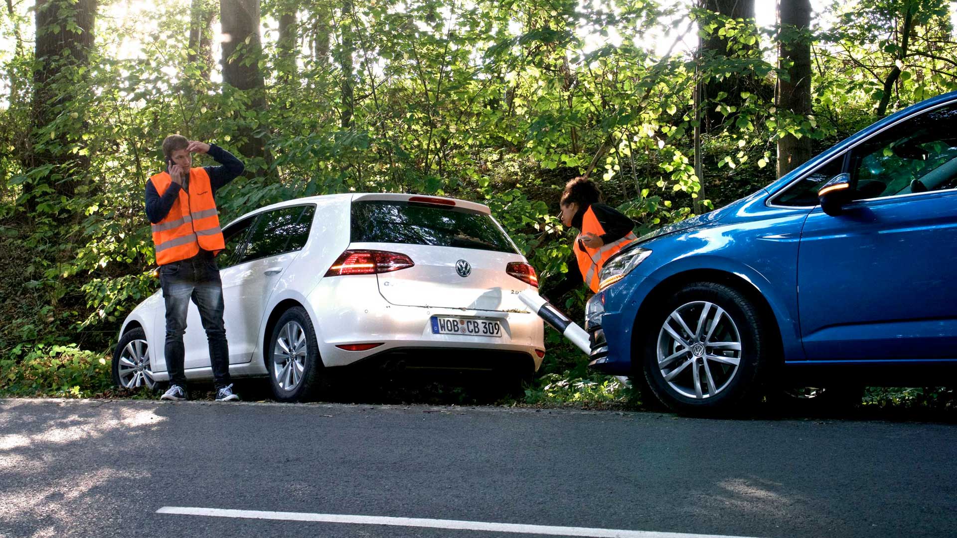 Symbolbild einer Unfallstelle, zwei Fahrzeuge, ein Mann am Telefon, keine Personenschäden