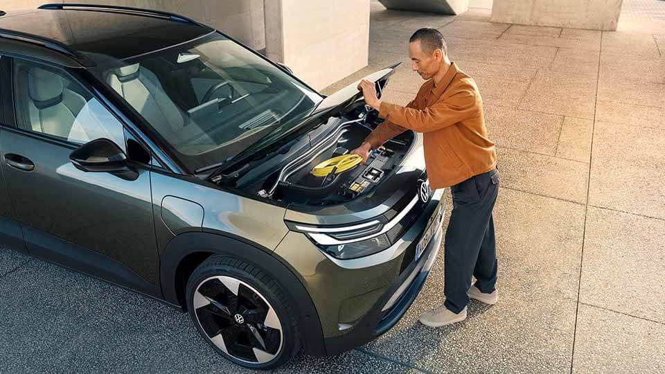 Volkswagen ID. Cross, Seitenansicht, Mann belädt den Frunk