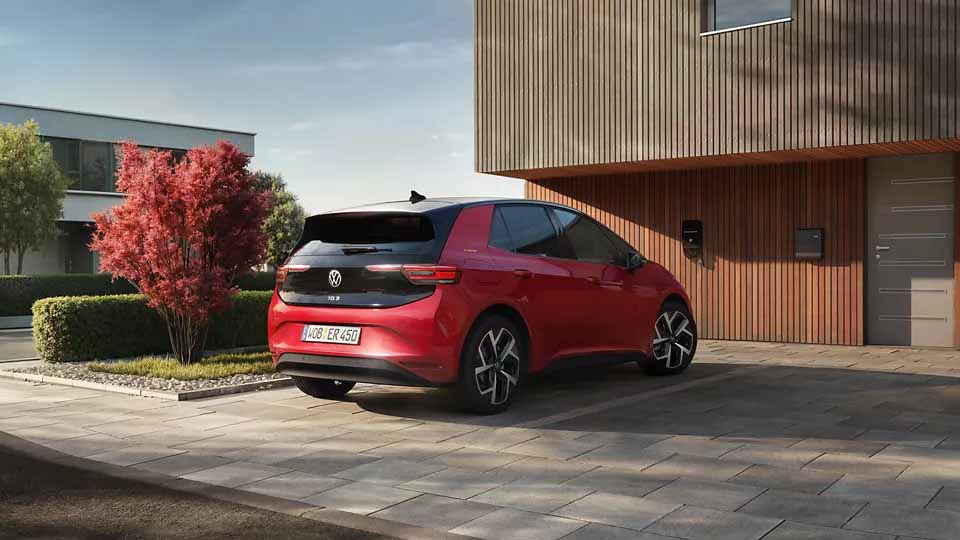 Volkswagen ID.3 ENERGY, rot, Heck-Seitenansicht, parkend vor Einfamilienhaus