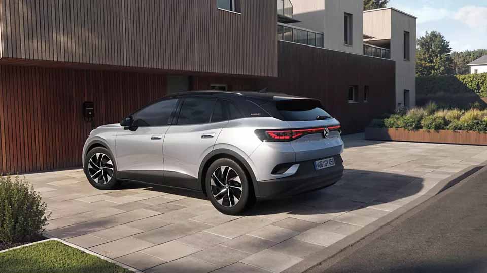 Volkswagen ID.4 ENERGY, silber-schwarz, Heck-Seitenansicht, parkend vor Einfamilienhaus