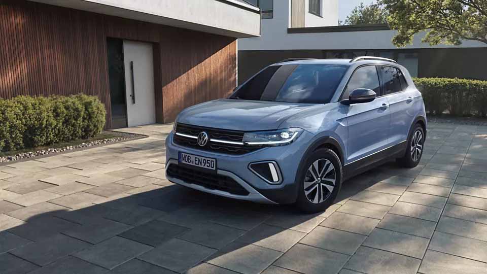 Volkswagen T-Cross ENERGY, hellblau, Front-Seitenansicht, parkend vor Einfamilienhaus