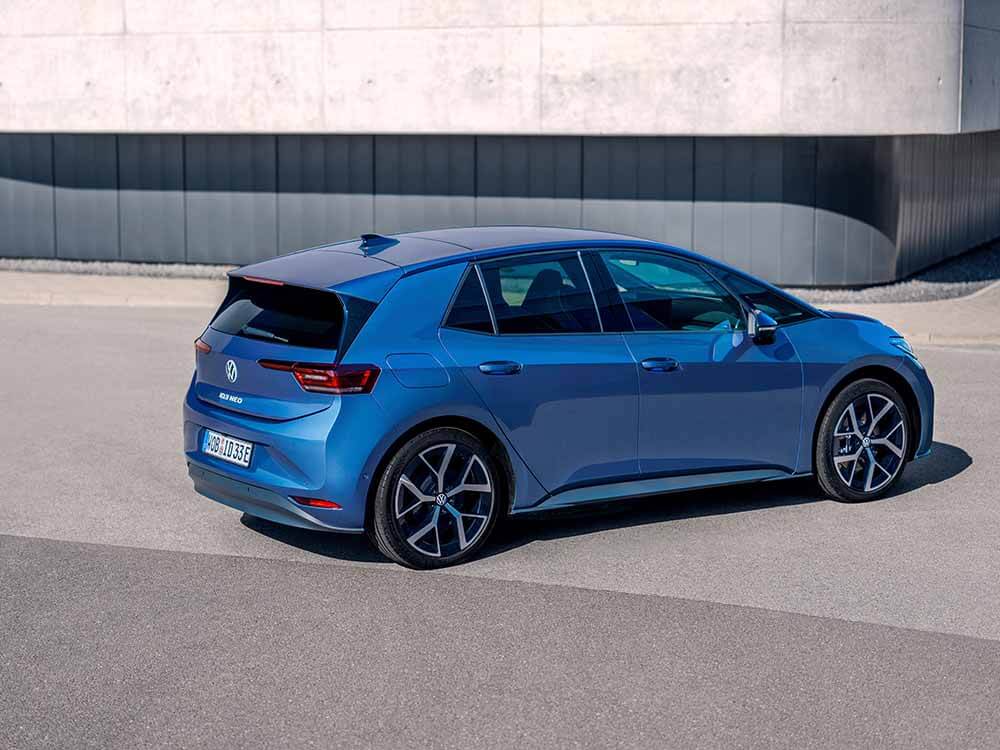 Volkswagen ID.3 Neo, blau, Heck-Seitenansicht vor grauer Fassade